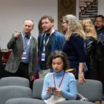 Grupa osób stoi i rozmawia podczas przerwy kawowej.